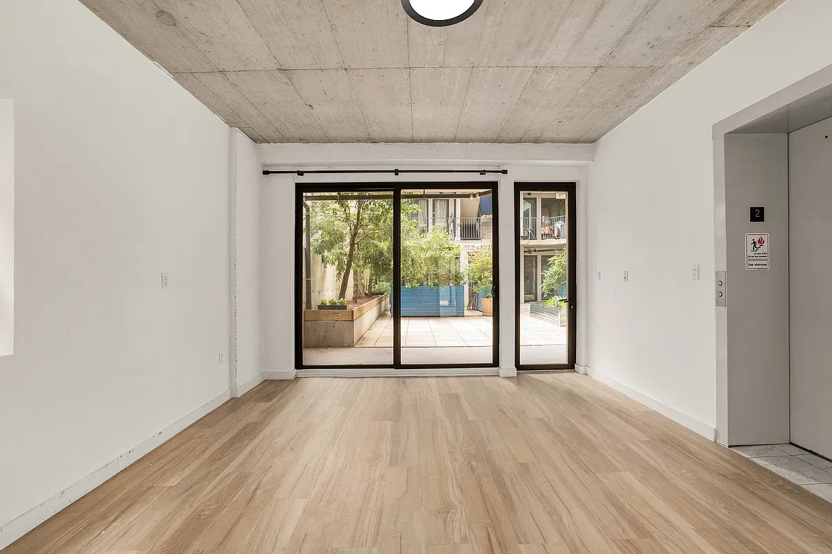 293 Hawthorne Street, Unit 2E Brooklyn, NY 11225 - Photo 8 of 21 a view of a room with wooden floor and doors