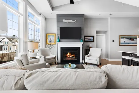 a living room with furniture a flat screen tv and a fireplace
