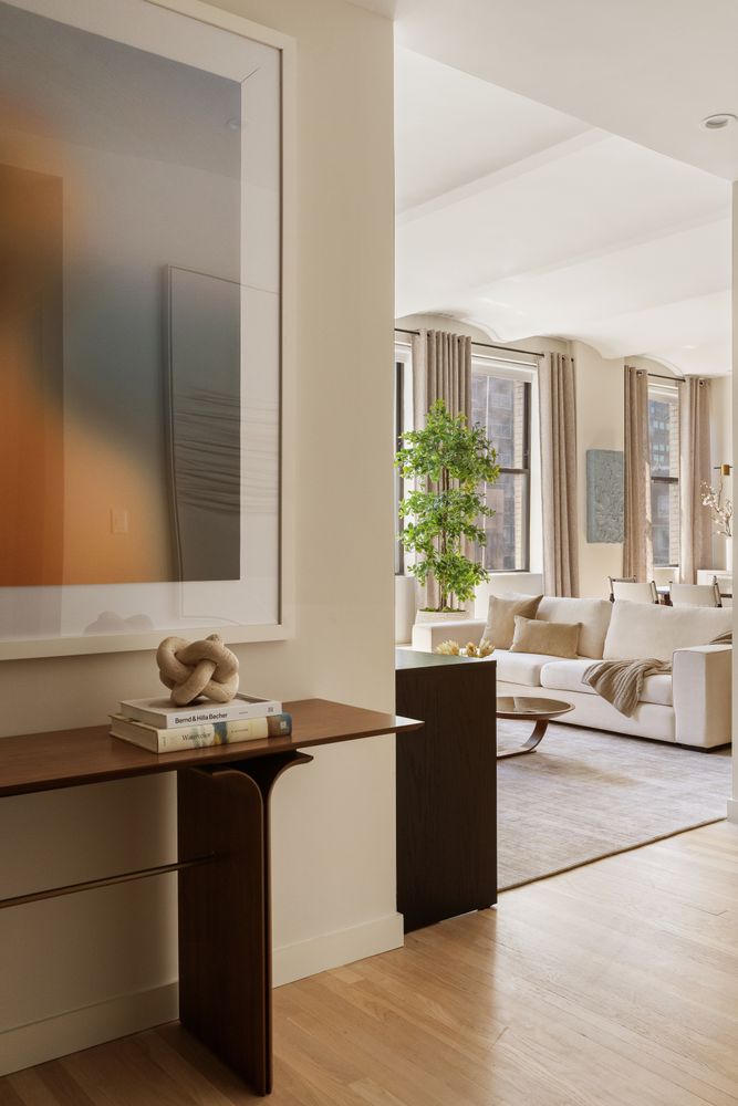 a living room with a large window and a potted plant