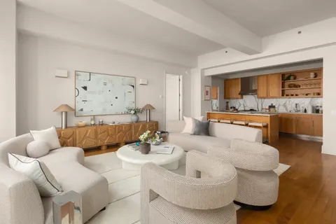 a living room with furniture and kitchen view