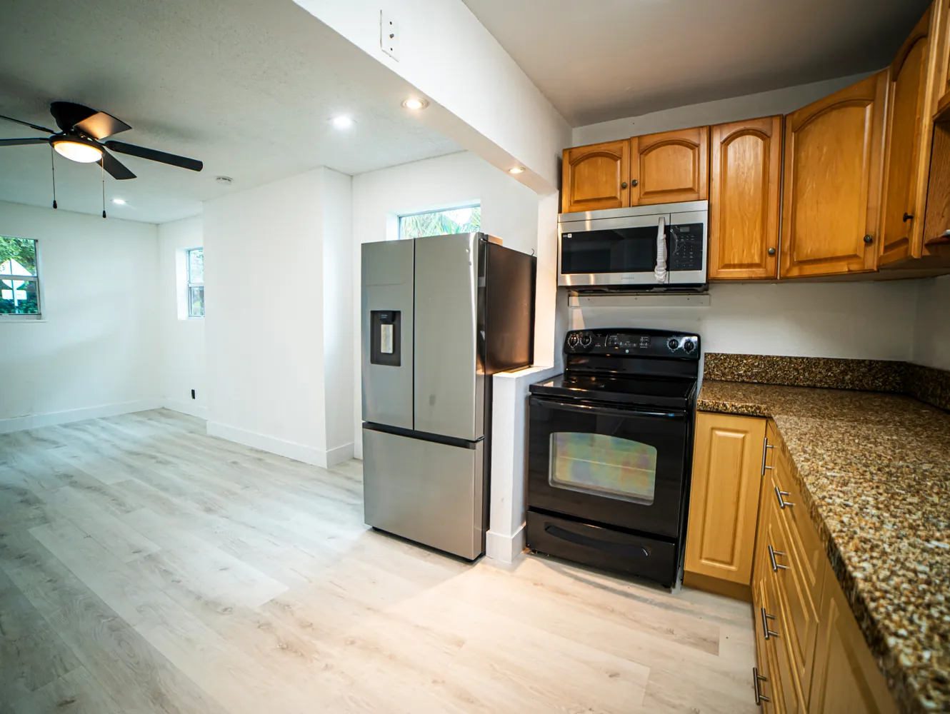 a kitchen with stainless steel appliances granite countertop a refrigerator stove and microwave