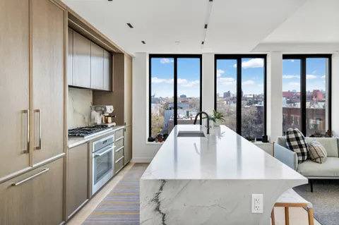 a kitchen with stainless steel appliances granite countertop a stove a sink and a refrigerator