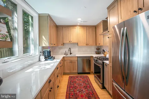 a kitchen with stainless steel appliances granite countertop a refrigerator sink and stove
