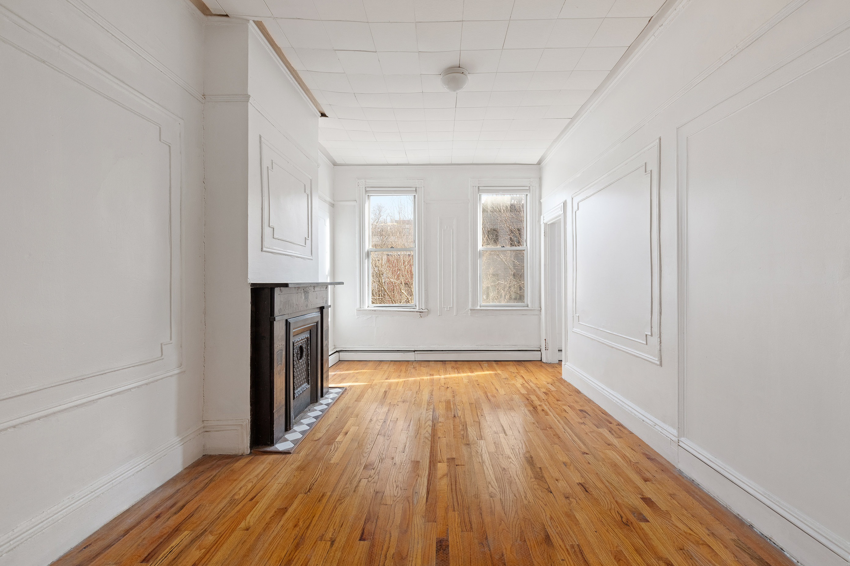 318 21st Street Brooklyn, NY 11215 - Photo 2 of 14 a view of an empty room with wooden floor and a window