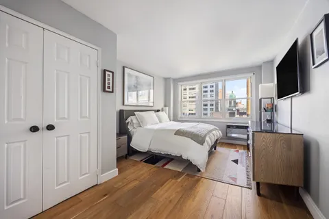 a bedroom with a bed furniture and a flat tv screen