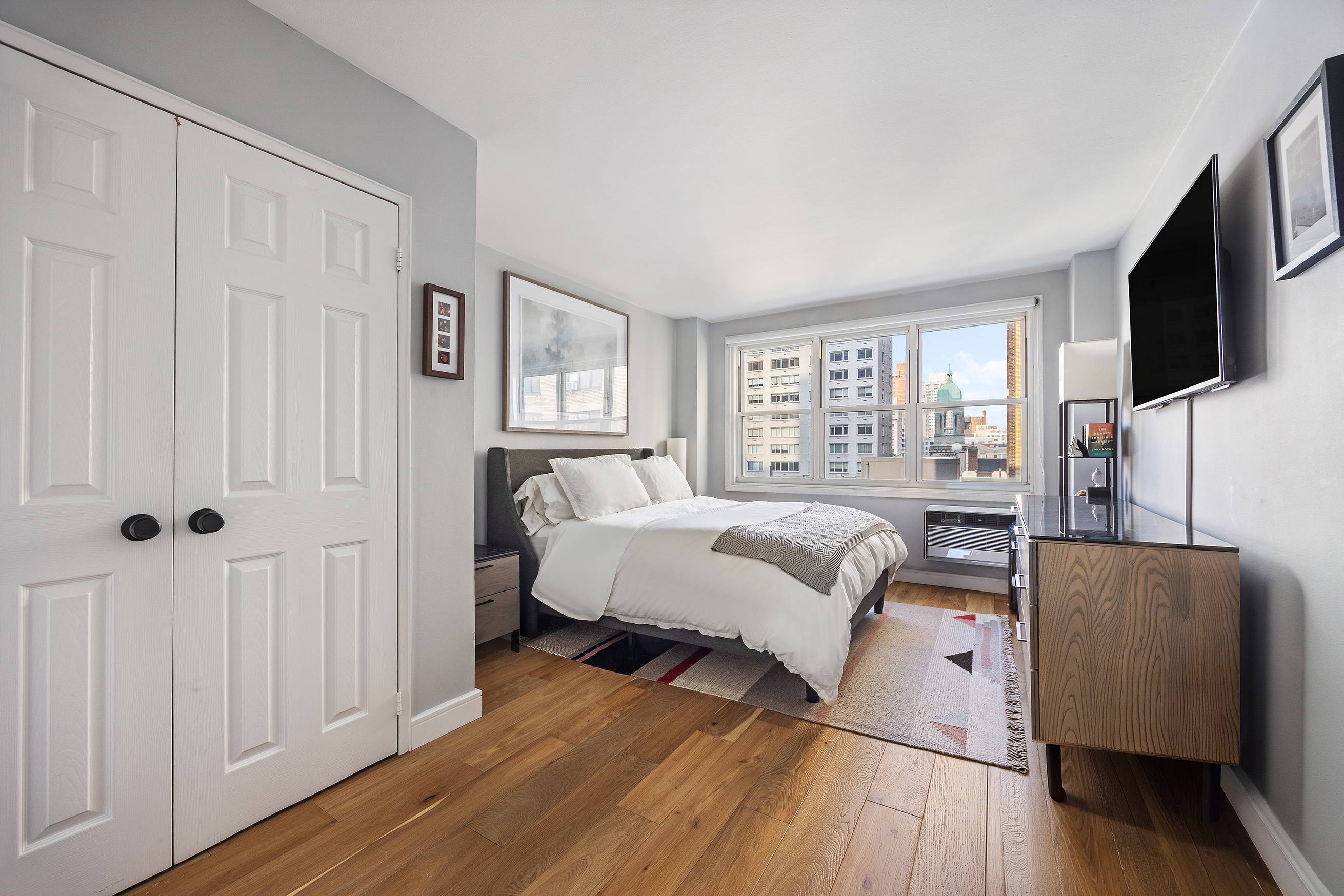 415 East 85th Street, Unit 7J Manhattan, NY 10028 - Photo 5 of 9 a bedroom with a bed furniture and a flat tv screen