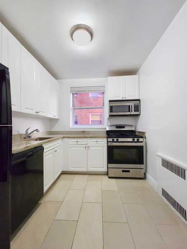 a kitchen with stainless steel appliances a stove top oven and cabinets