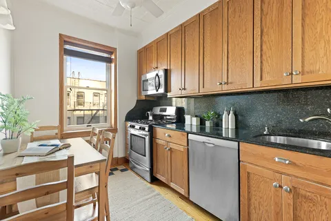 a kitchen with stainless steel appliances granite countertop a stove a sink dishwasher and cabinets with wooden floor