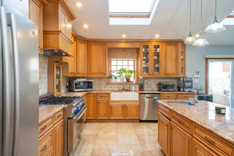 a kitchen with stainless steel appliances granite countertop a sink stove and refrigerator
