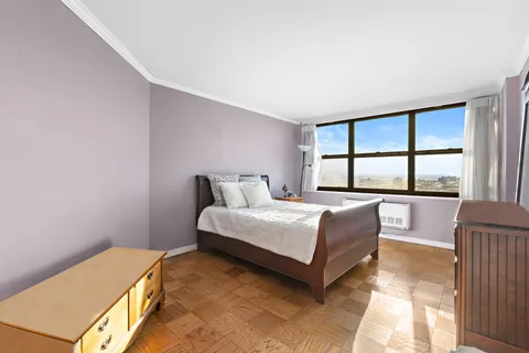 a bedroom with a bed and a large window