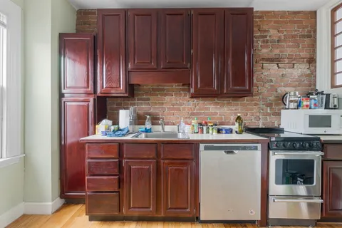 a kitchen with stainless steel appliances granite countertop wooden cabinets and a counter top space