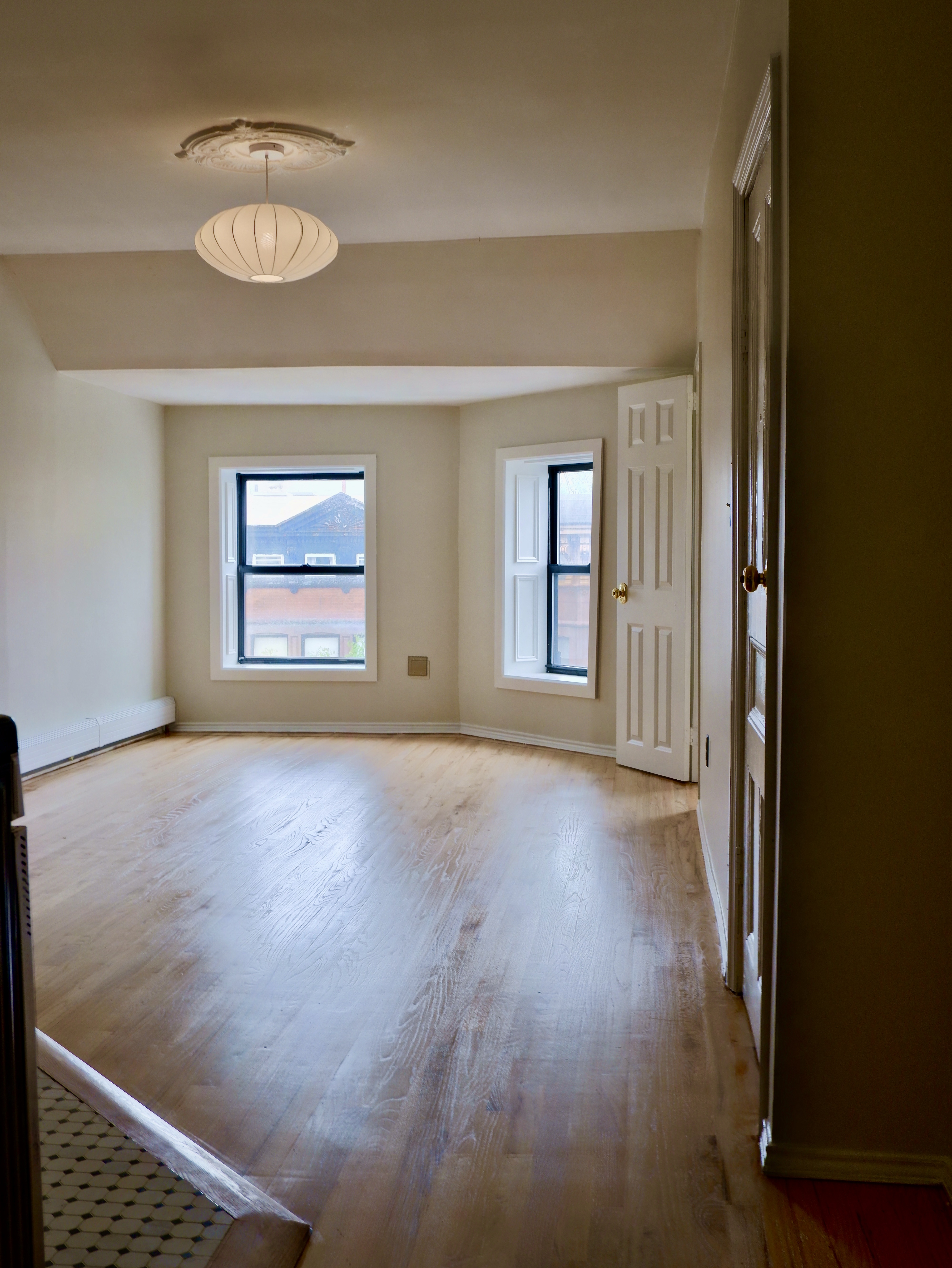 132 Decatur Street, Unit 3 Brooklyn, NY 11216 - Photo 4 of 17 en empty room with windows and wooden floor