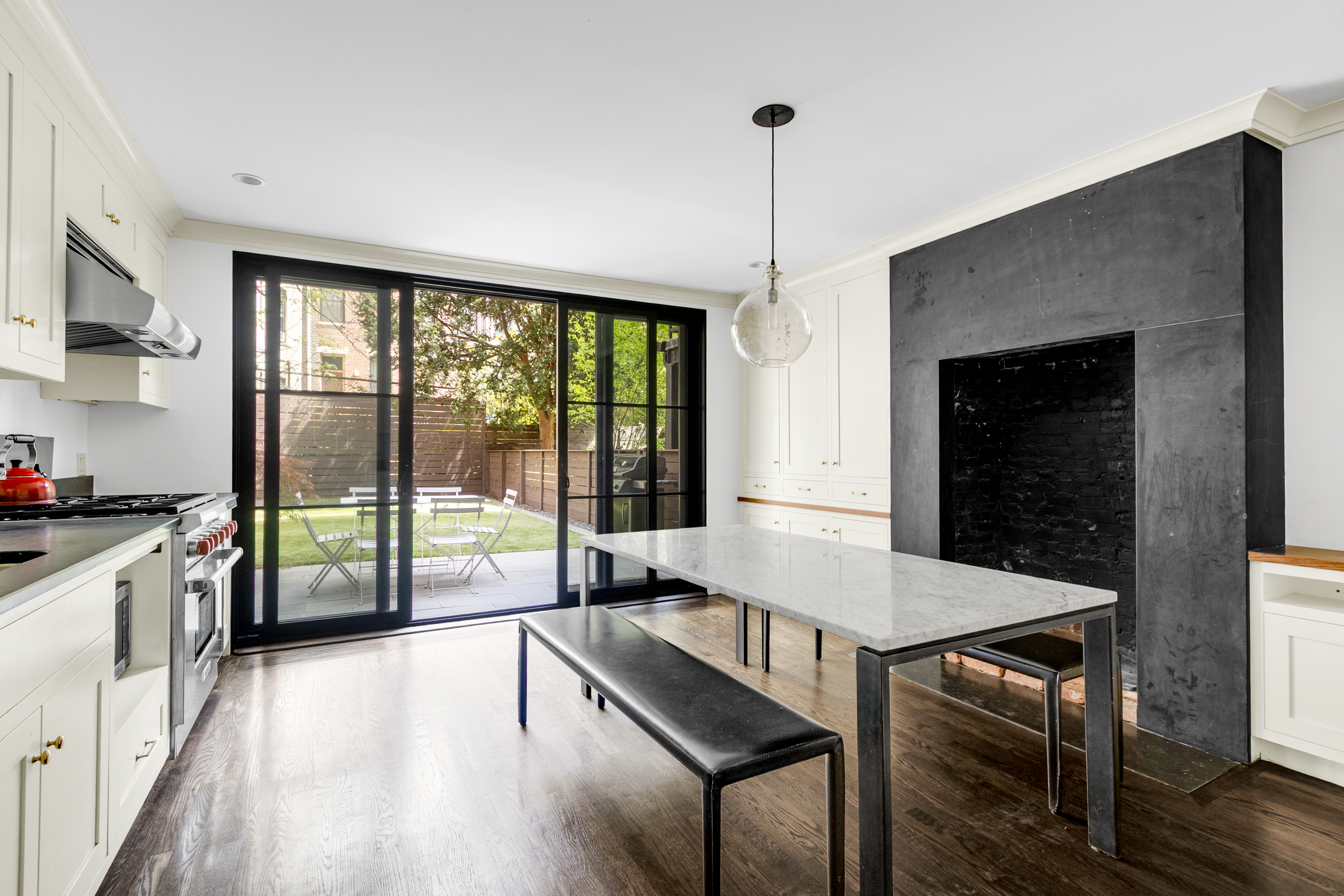 125 West 132nd Street Manhattan, NY 10027 - Photo 2 of 21 a kitchen with a table chairs stove and wooden floor