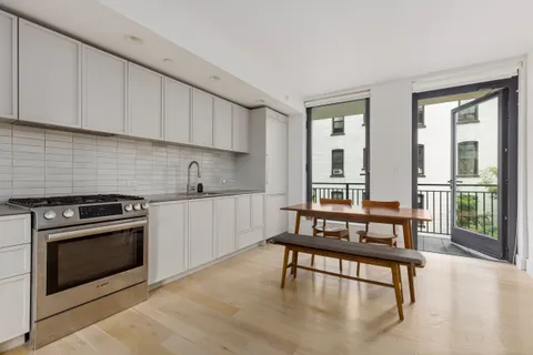 a kitchen with stainless steel appliances granite countertop a stove a sink and a white cabinets