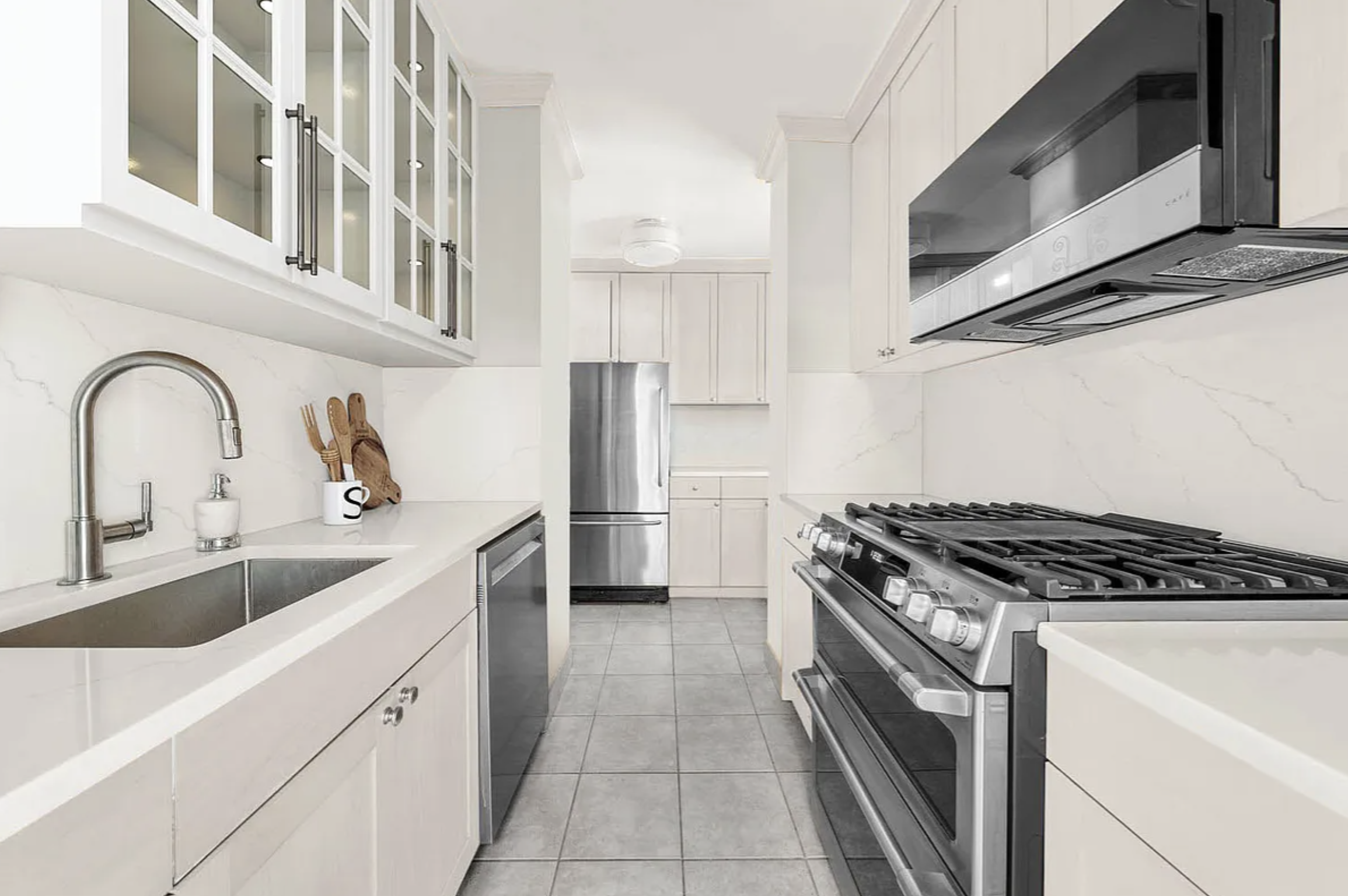 35 Sutton Place, Unit 10G Manhattan, NY 10022 - Photo 2 of 8 a kitchen with stainless steel appliances granite countertop a sink and a stove