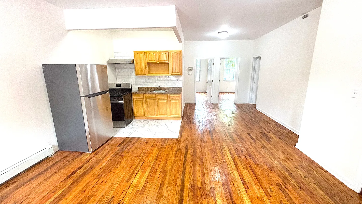 a view of a kitchen with a sink and a refrigerator