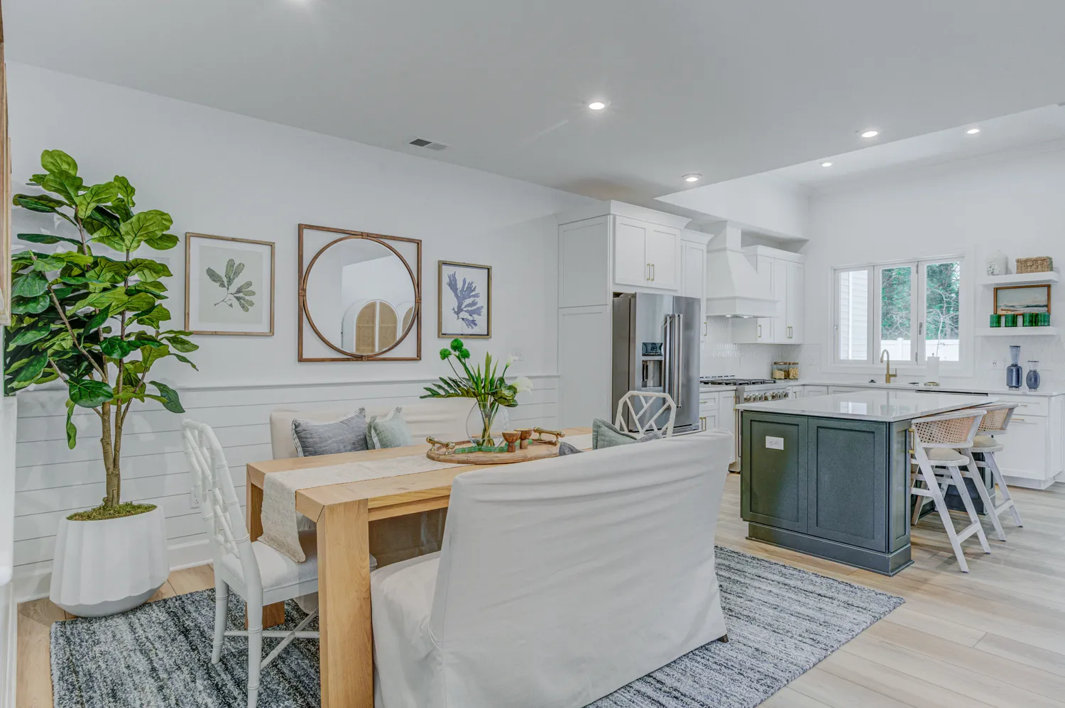 a kitchen with stainless steel appliances kitchen island granite countertop a stove a sink a dining table and chairs