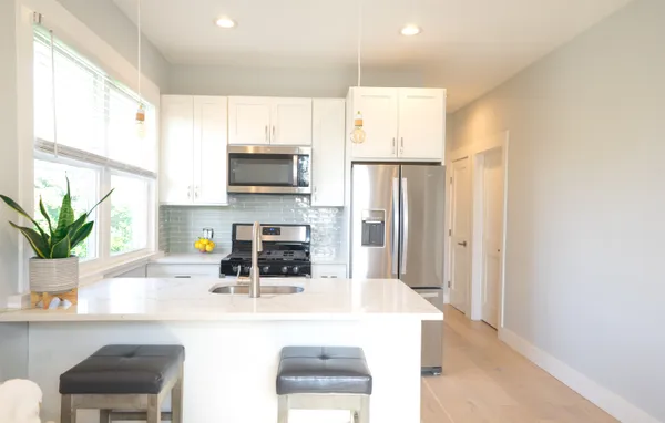 a kitchen with stainless steel appliances a microwave a sink and cabinets
