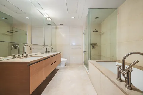 a large bathroom with a double vanity sink a mirror and a bathtub