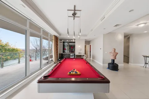a room with pool table and windows