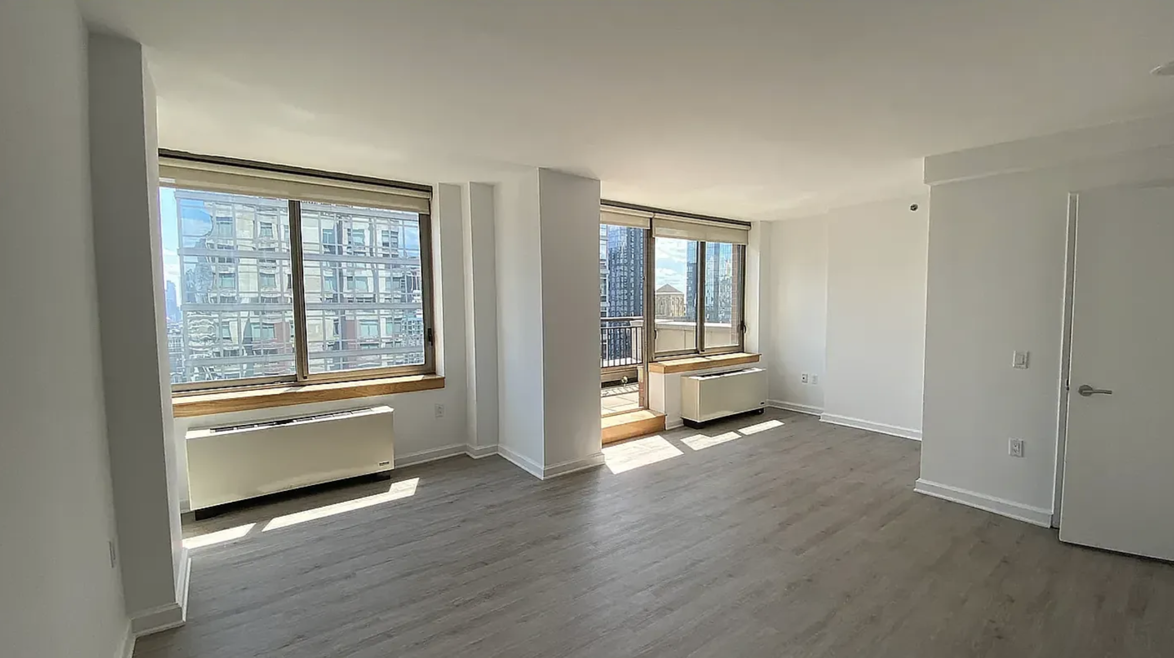 35 West 33rd Street, Unit 32C Manhattan, NY 10001 - Photo 6 of 21 a view of an empty room with a window and wooden floor