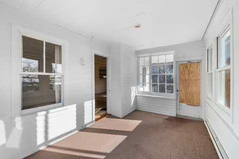 an empty room with windows and chandelier