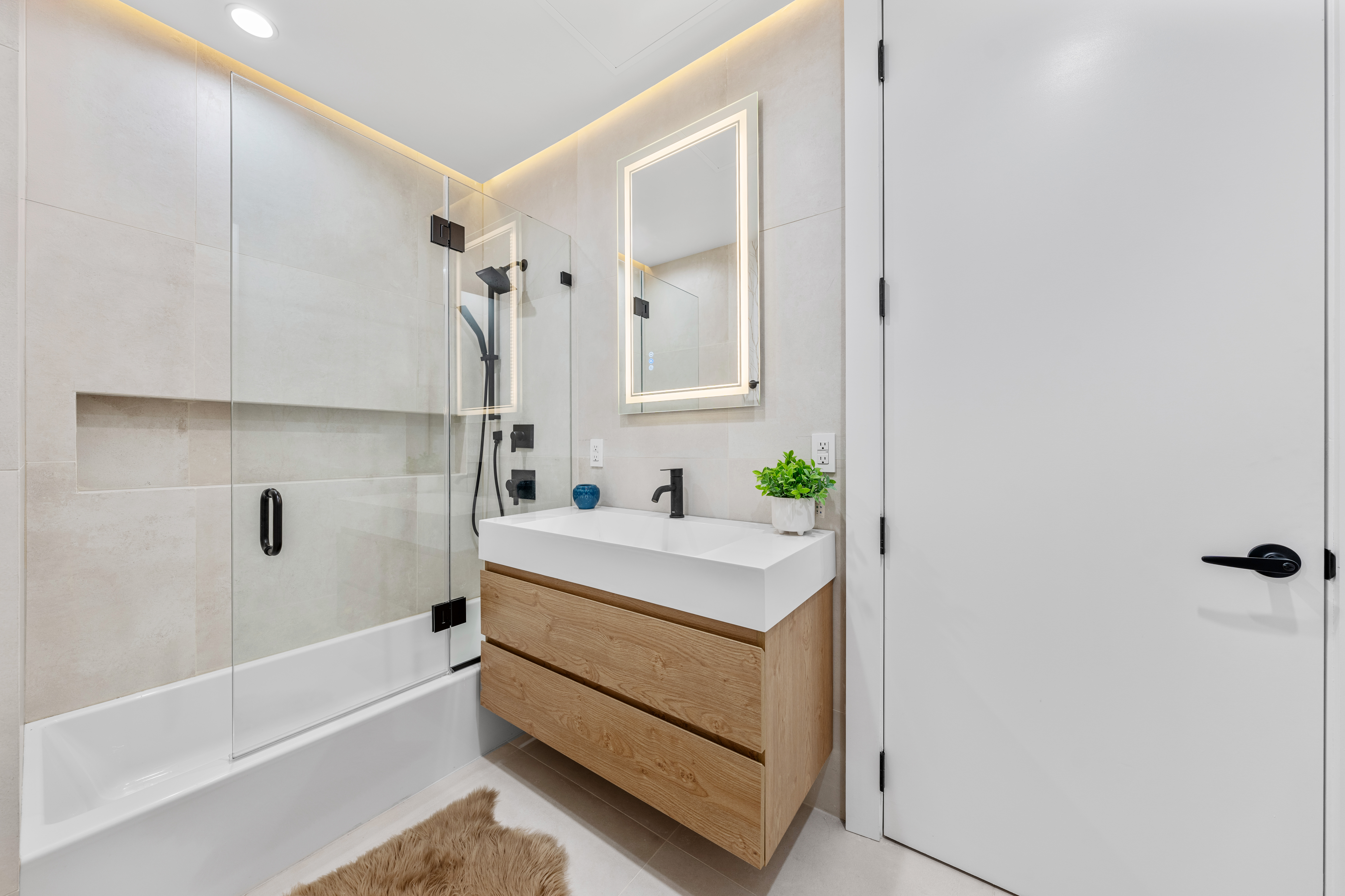 545 Lexington Avenue, Unit 1 Brooklyn, NY 11221 - Photo 6 of 19 a bathroom with a bathtub sink and mirror