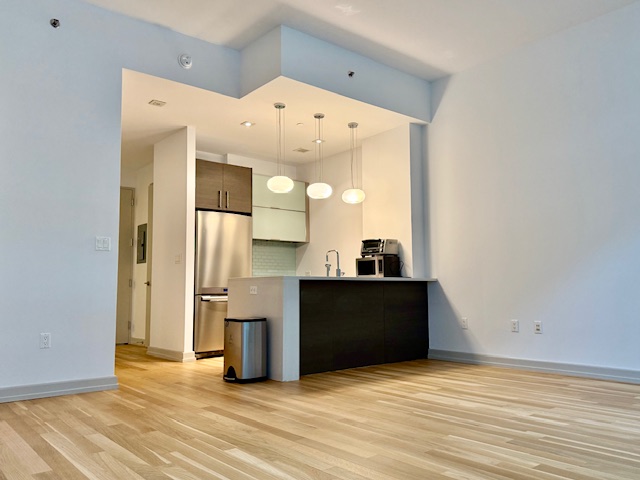 21-45 44th Drive, Unit 1H Queens, NY 11101 - Photo 1 of 7 a view of a kitchen with wooden floor