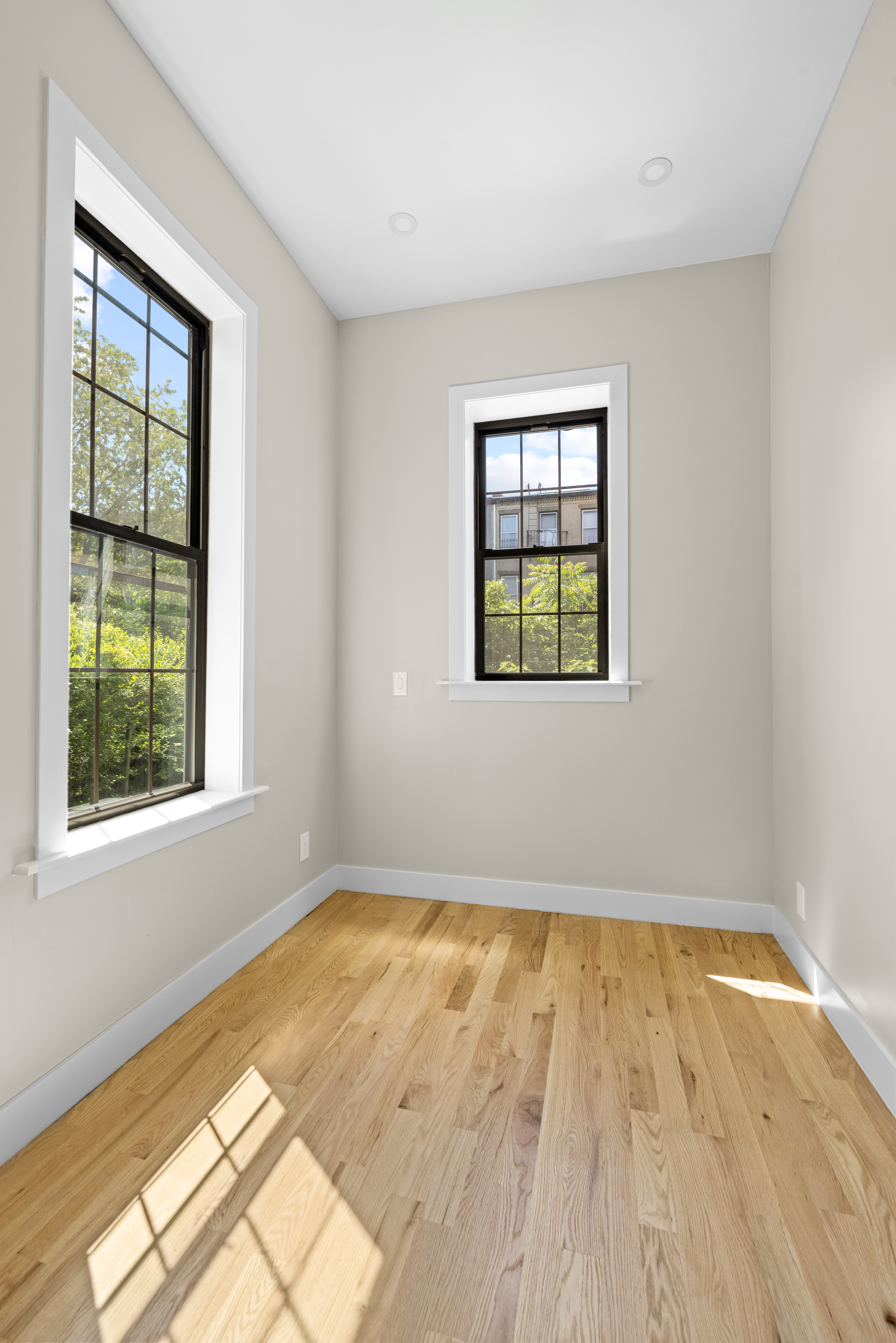 456 Willoughby Avenue, Unit 1 Brooklyn, NY 11206 - Photo 5 of 14 an empty room with wooden floor and windows