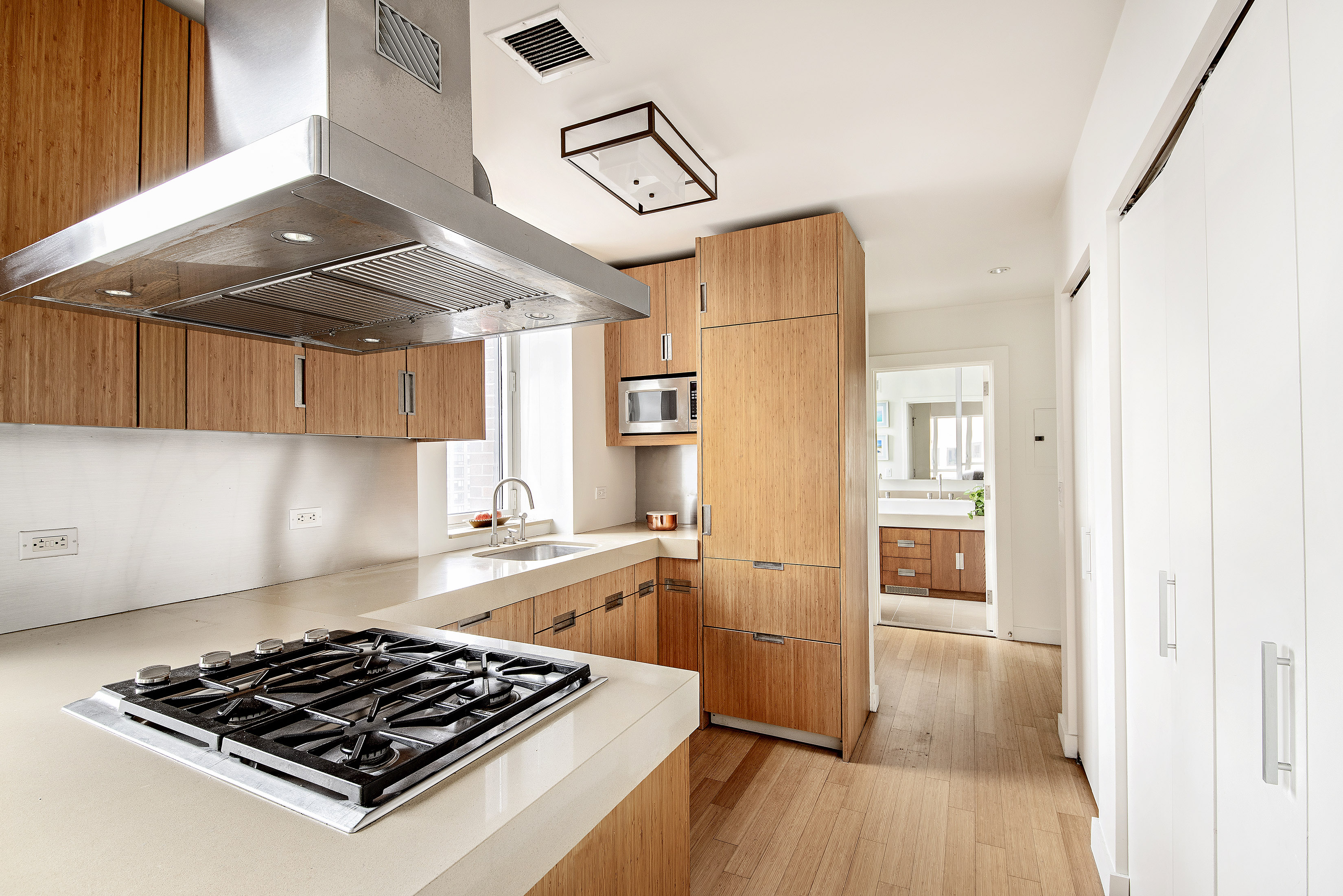 450 West 17th Street, Unit 1021 Manhattan, NY 10011 - Photo 3 of 5 a kitchen with stainless steel appliances granite countertop a stove a refrigerator and a view of living room
