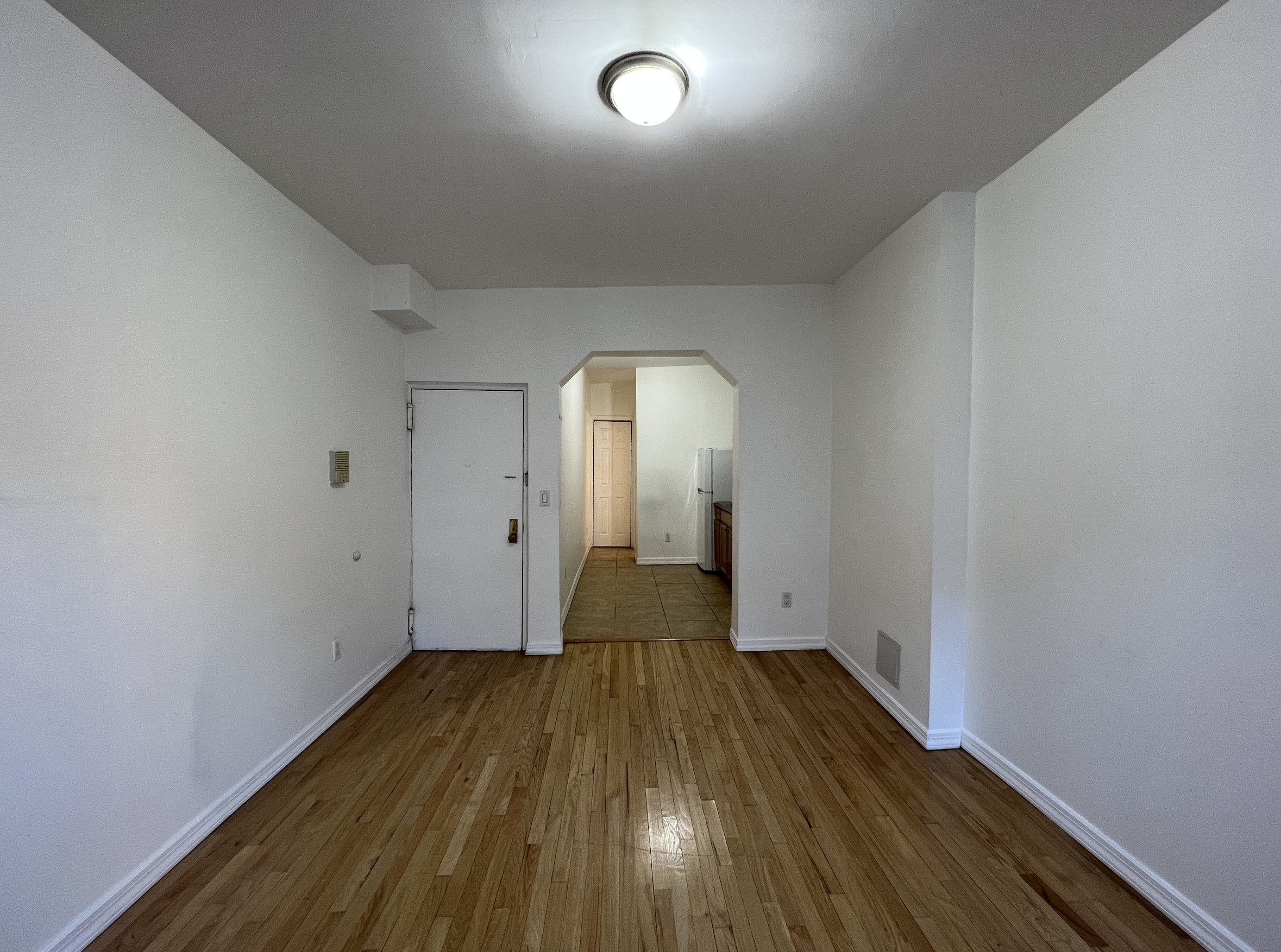 446 West 46th Street, Unit 5 Manhattan, NY 10036 - Photo 4 of 15 an empty room with wooden floor and windows