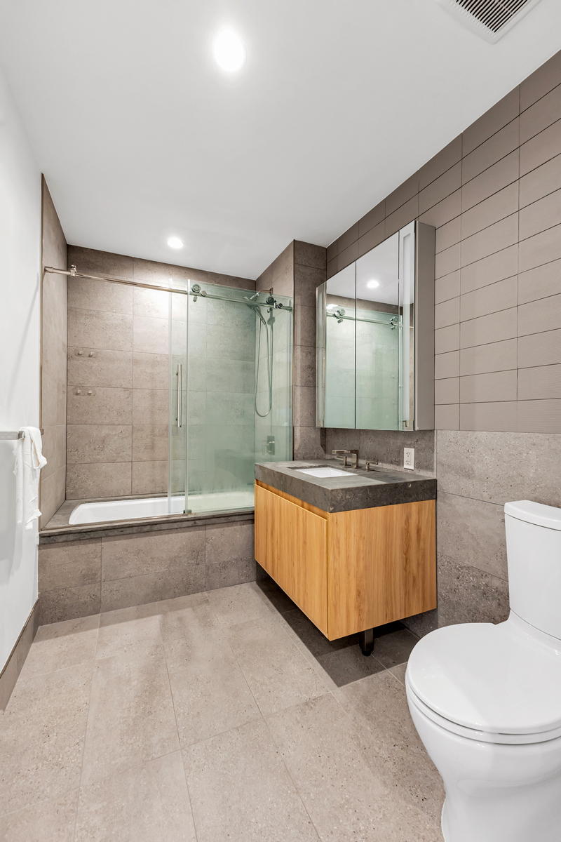 24-16 Queens Plaza South, Unit 4J Queens, NY 11101 - Photo 4 of 15 a bathroom with a tub and mirror