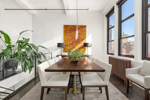 a view of a dining room with furniture and a potted plant
