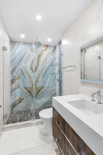 a bathroom with a sink a toilet and shower