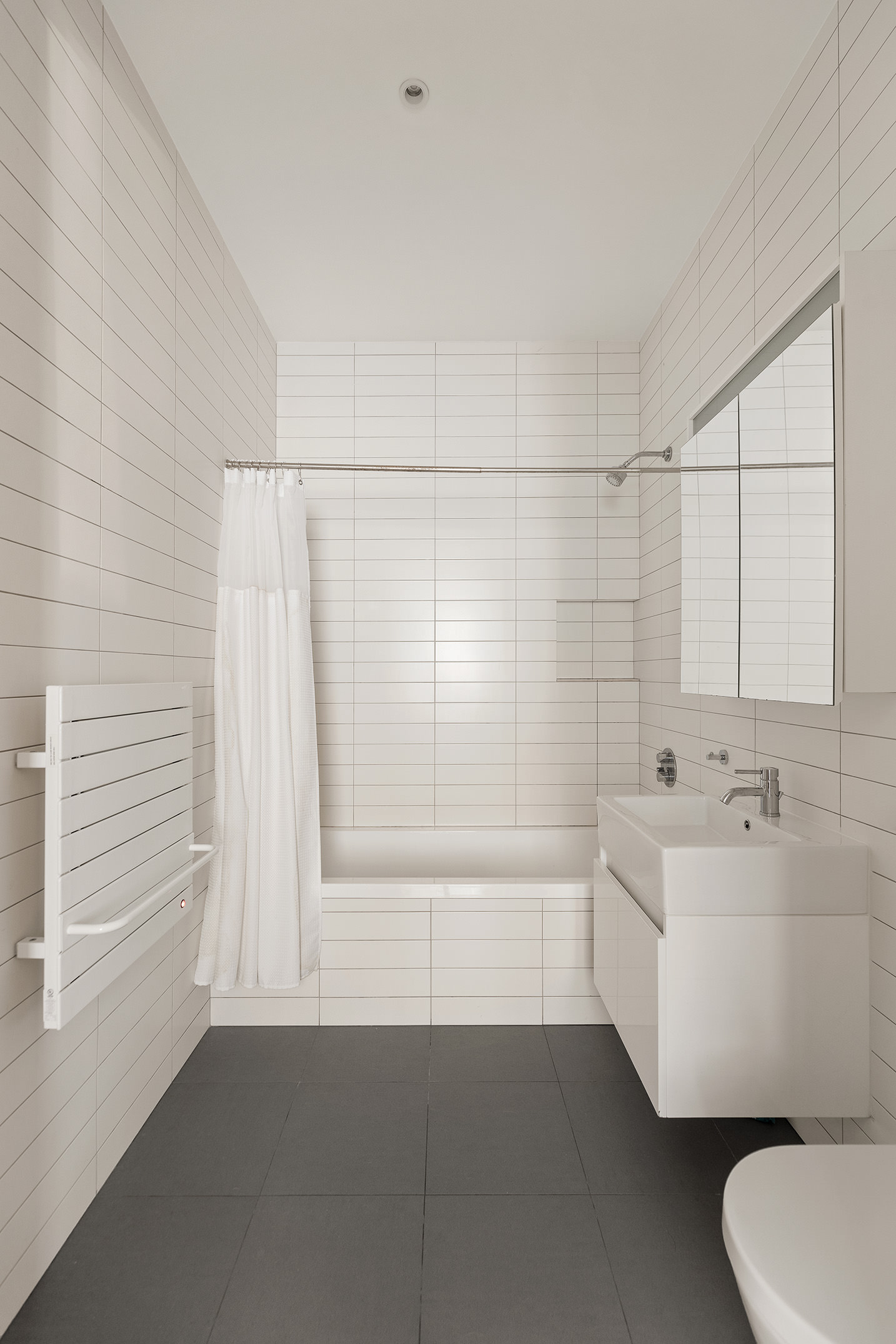 68 Spring Street, Unit 3R Manhattan, NY 10012 - Photo 6 of 9 a bathroom with a bathtub sink and toilet