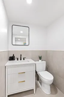 a bathroom with a toilet sink and mirror