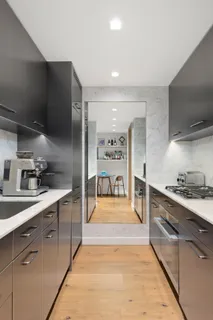 a large kitchen with stainless steel appliances kitchen island granite countertop a sink and a stove top oven with wooden floor