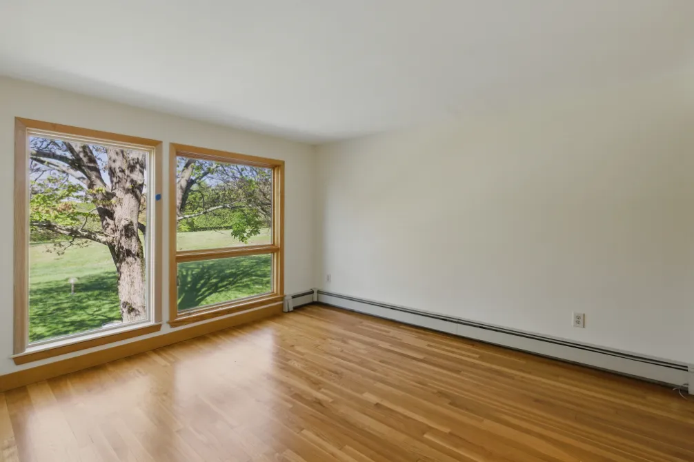 a view of room with window and wooden floor