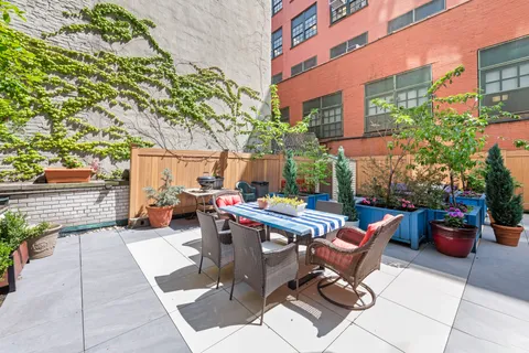 a view of backyard with outdoor seating and plants
