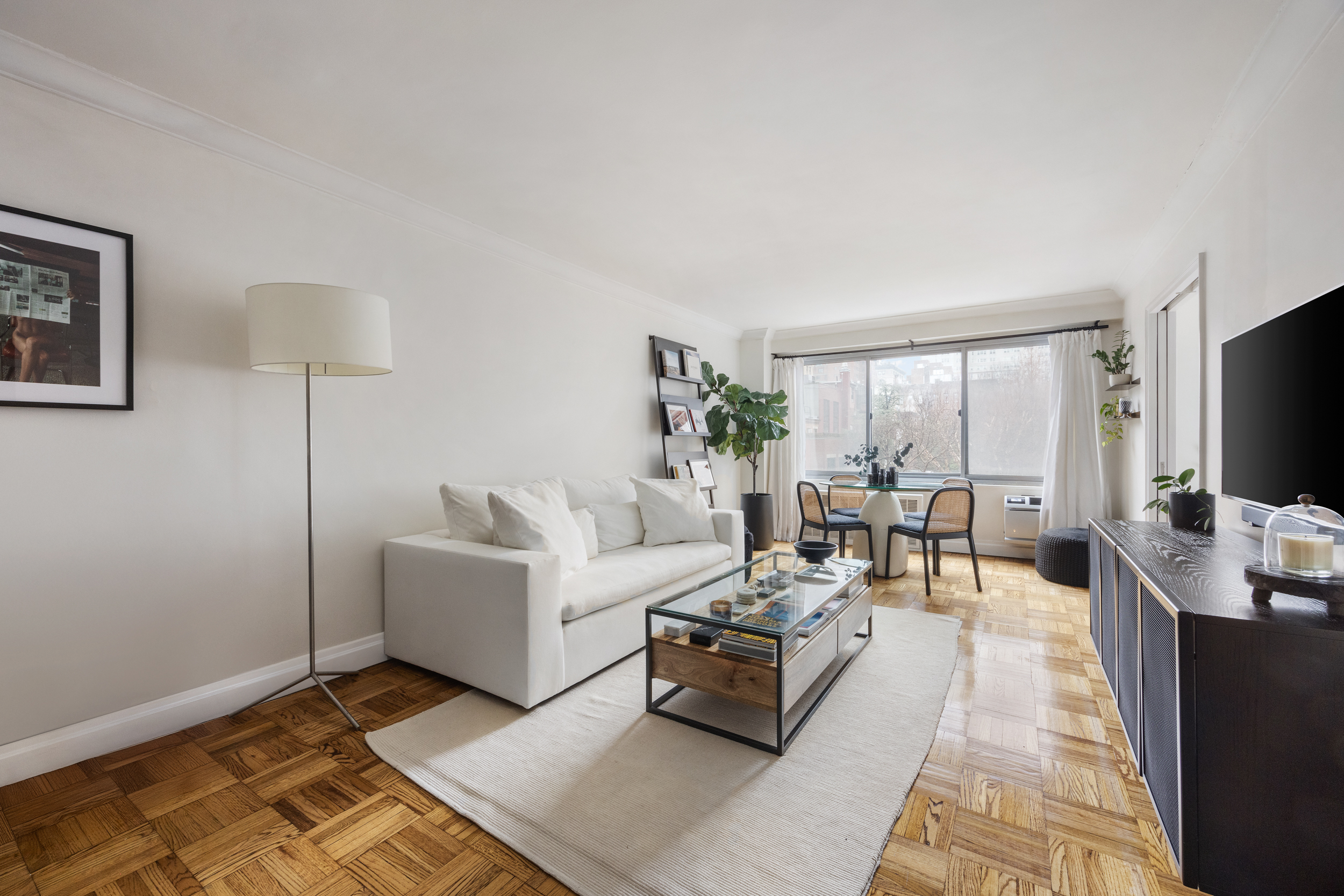 175 West 12th Street, Unit 4L Manhattan, NY 10011 - Photo 1 of 11 a living room with furniture and a flat screen tv