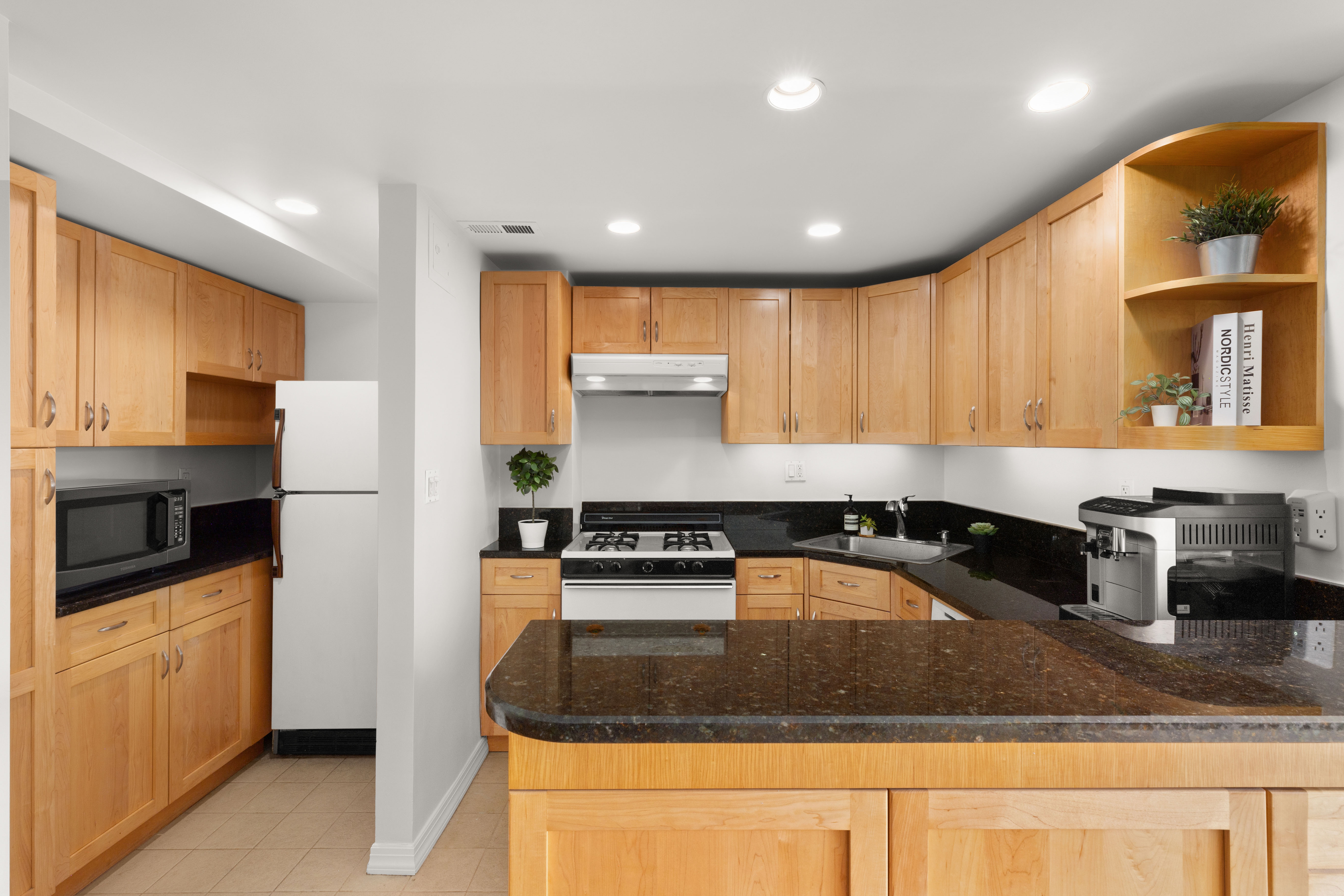 150 East 56th Street, Unit 2A Manhattan, NY 10022 - Photo 4 of 10 a kitchen with stainless steel appliances granite countertop a sink a stove and a refrigerator