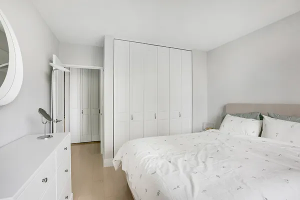 a bedroom with a bed and a large mirror