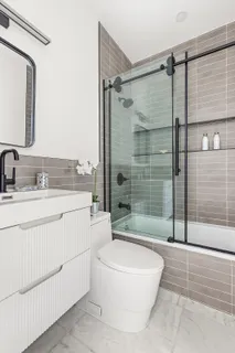 a bathroom with a sink a toilet and shower