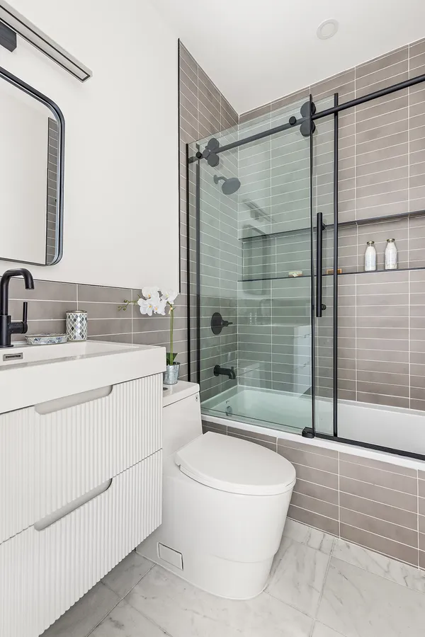 a bathroom with a sink a toilet and shower
