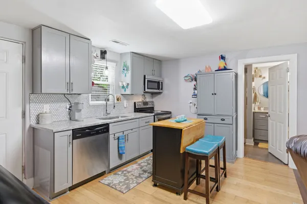 a kitchen with stainless steel appliances granite countertop a sink stove and wooden floor