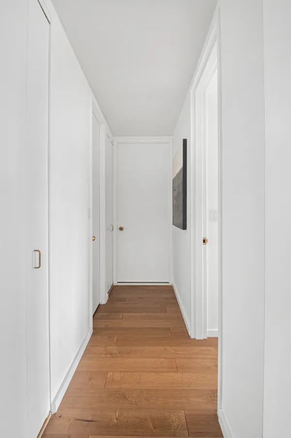 a view of a hallway with wooden floor and staircase