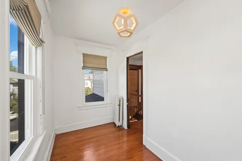 a view of a room with wooden floor and window