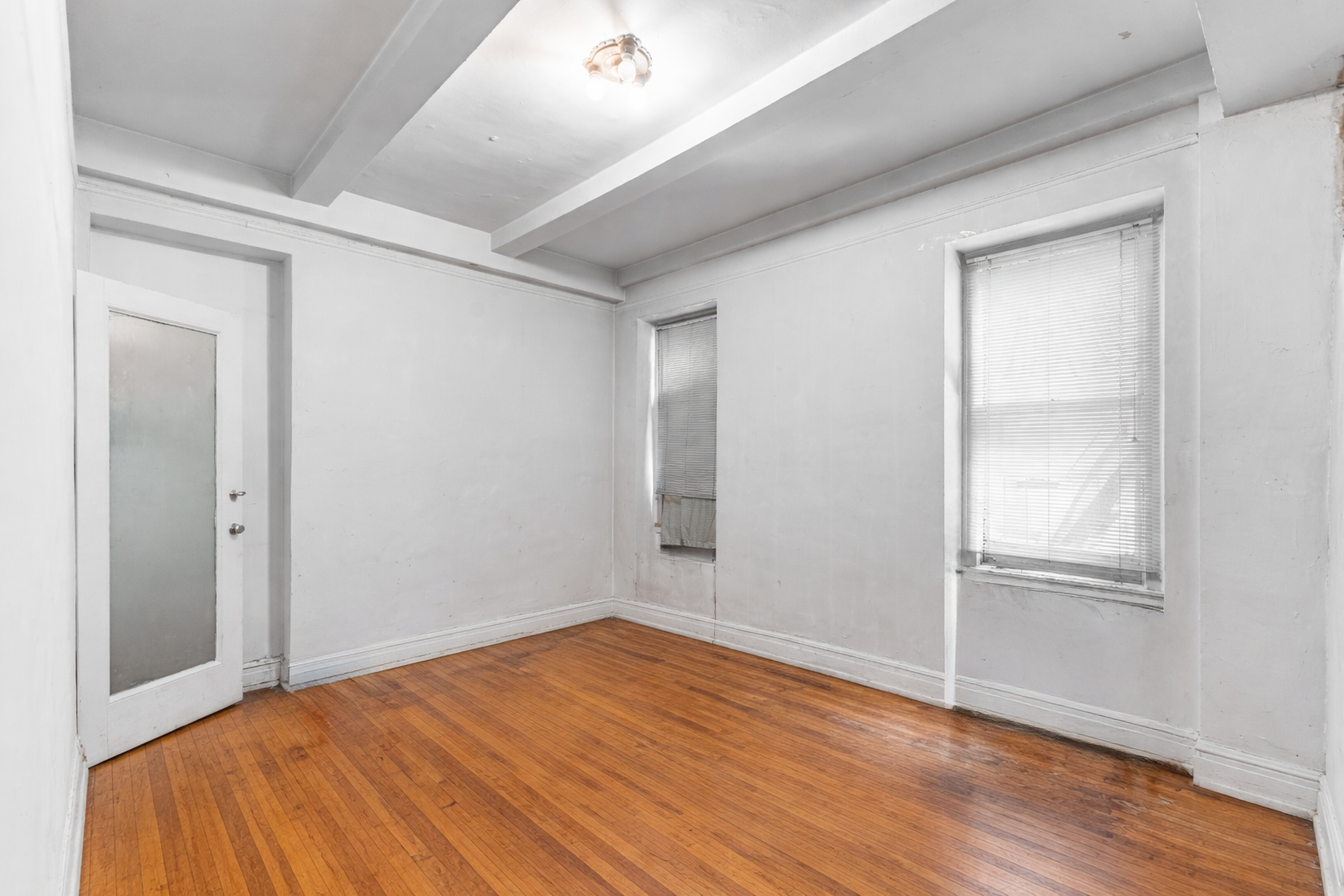 302 West 86th Street, Unit 1C Manhattan, NY 10024 - Photo 6 of 16 an empty room with wooden floor & closet