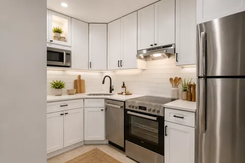 a kitchen with stainless steel appliances granite countertop a refrigerator sink and stove