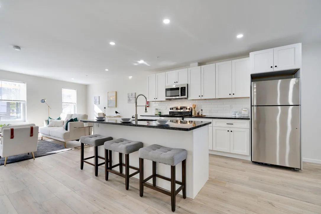 a living room with furniture and a refrigerator